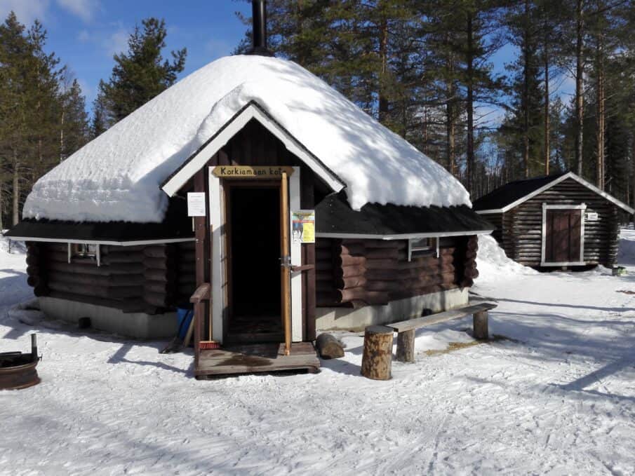 Kota Korkiamaassa. Lunta maassa sekä kodan katolla. Keväinen kuva.